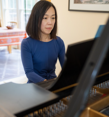 Jiyoung Oh reading music composition while playing piano