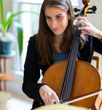 Lauren Latessa seated facing forward playing the cello